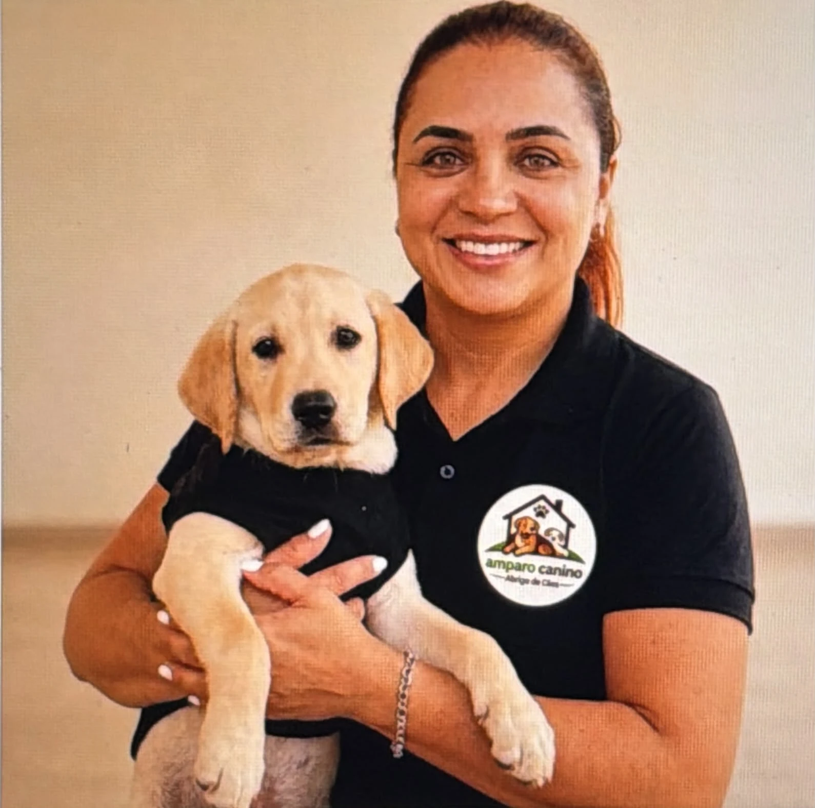 Protetora sorrindo segurando um gato branco e cinza no colo